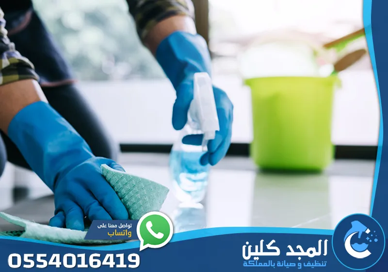 عقد نظافة نطاق بلدية العليا والسليمانية 0554016419 المجد كلين عامل نظافة ينظف أسطح المطبخ باستخدام قفازات ومواد تنظيف لإزالة الدهون والبقع.